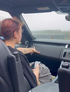 a woman sitting in the driver's seat of a car