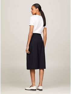 Tommy Hilfiger women's skirt. Our sophisticated spin on the midi skirt boasts an asymmetrical wrap closure and gold-tone TH crest buttons for an elevated finish.  Material: 47% Viscose. Asymmetrical Pleated Wrap Skirt For Work, Classic A-line Bottoms For Workwear, Lined Midi Wrap Skirt For Workwear, Classic A-line Workwear Bottoms, Classic Asymmetrical Skirt For Work, Midi Wrap Skirt For Workwear, Midi Wrap Skirt With Lining For Work, Relaxed Fit Midi Wrap Skirt For Work, Classic A-line Bottoms For Office