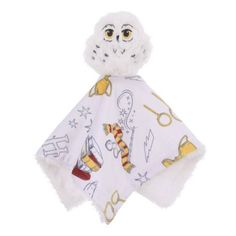 a white stuffed animal with scissors on it's head and scarf around its neck