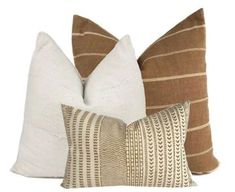 three pillows with different patterns on them, one is brown and the other is white