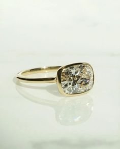 a yellow gold ring with a white diamond