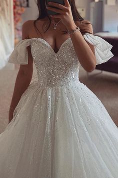 a woman taking a selfie wearing a wedding dress with sequins on it