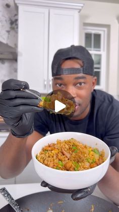 a man in black gloves holding a white bowl filled with food