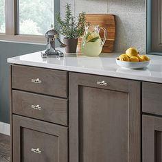 a kitchen counter with some lemons on it and a bowl of fruit in the middle