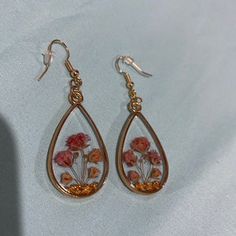 a pair of earrings with flowers painted on them