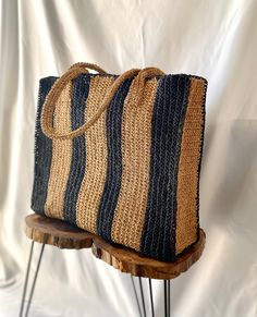 a black and tan striped bag sitting on top of a wooden table next to a white wall