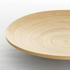 an empty wooden plate on a white surface with no one around it or someone else