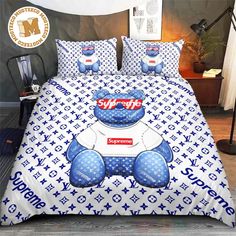 a blue and white bed with a large teddy bear on it's coverlet