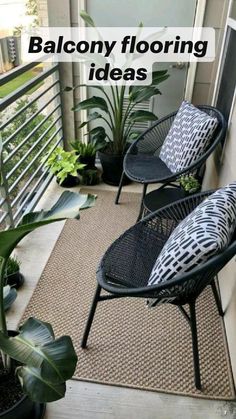 two black chairs sitting on top of a balcony next to plants