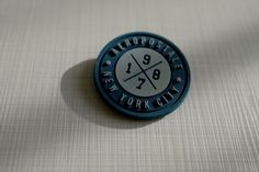 a blue and white pin with the words metropolitane new york city on it's side