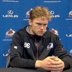 a man sitting at a table in front of a microphone