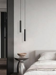 a white bed sitting in a bedroom next to a tall wall mounted light above it