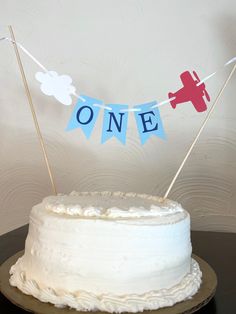 a white cake topped with frosting and two small red airplanes on top of it