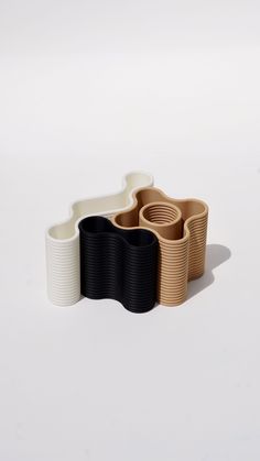 three cups sitting next to each other on top of a white surface with one cup in the middle