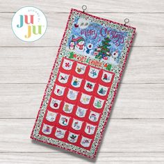 a quilted christmas calendar hanging on a wooden background with the words joy and joy