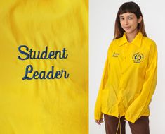 "Vintage 80s windbreaker jacket in yellow with Student Leader and Sheridan Street School on the chest. Snaps up the front. Please see measurements and condition below. Every garment we sell is authentic vintage! You will receive the exact item photographed. Condition: Very good vintage. Has a couple faint spots that should come out with cleaning. Has some wear to the paint on the snaps. Best fits women's: Labelled Medium Best fits men's: Small Tag: nylons Material:  Nylon MEASUREMENTS Taken from seam to seam while the garment is lying flat. Double the armpit, waist, and hips For reference, model is 5'9\" and measures 35-27.5-39. Length from Top: 27\" Armpit to Armpit: 23\" Waist: 23\" Shoulder to Shoulder: 20\" Sleeve: 24\" For sales and promotions, follow us @Shopexile" Casual Yellow Outerwear For School, Retro Yellow Windbreaker For Fall, Retro Yellow Windbreaker For Spring, Vintage Yellow Long Sleeve Windbreaker, Yellow Vintage Long Sleeve Windbreaker, Yellow Retro Windbreaker For Streetwear, 80s Windbreaker, Cream Mini Dress, Kawaii Sweater