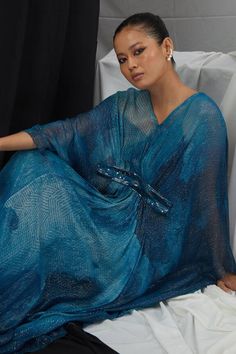 Jade blue kaftan with blotch print, lurex stripes and placement hand embroidery. Comes along with an inner slip.
Components: 2
Pattern: Hand Embroidery, Print
Type Of Work: Blotch, Geometric
Neckline: V Neck
Sleeve Type: Batwing Sleeves
Fabric: Lurex, Nokia Silk
Color: Blue
Other Details: 
Note: Only the outfit mentioned in the description is being sold
Occasion: Resort - Aza Fashions Blue Kaftan, Embroidery Print, Types Of Work, Batwing Sleeve, Bat Wings, Aza Fashion, Sleeve Type, Hand Embroidery, Jade