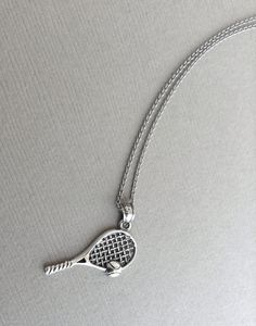 a tennis racquet pendant on a silver chain