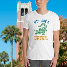 Florida Gators T Shirt Short Sleeve Get ready for any University of Florida game with this Florida Gator short sleeve t shirt. Made of durable combed ring-spun cotton fabric with double-stitched hem and sleeves.• White: 100% cotton• Silver: 90% cotton + 10% polyester• Pre-shrunk for extra durability • Unisex Fit Top Selling Classic t-shirt that fits both men and women. It's a customer favorite! Style + Fit Standard length. Regular Fit. This fabric easily gives into movement. Source Blank shirt i Gator Shirts, Florida Gator Shirts, Florida Tshirt, Cotton Short Sleeve T-shirt With Fish Print, Gainesville Florida, Florida Gator, Graphic Print Short Sleeve T-shirt For Fishing, Short Sleeve Fish Print T-shirt For Fishing, Magazines For Kids