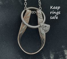 a necklace with two rings on it and the words keep rings safe written in silver