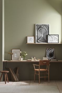 a desk with two chairs and pictures on the wall