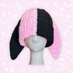 a crocheted hat on top of a mannequin's head with hearts in the background