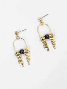 These Art Deco inspired earrings feature sleek, modern design elements, highlighting the contrast between the rich, dark hues of the black, semi precious Agate stone and the radiant golden brass. Each earring boasts a distinctive arched geometric shape inspired by the Art Deco style, lending a sense of elegance and sophistication.  The stepped cut brass fringe creates movement and shine and adds to the uniqueness and contemporary design.  Their minimalist yet bold design embodies a harmonious balance between simplicity and intricacy, making them a versatile accessory suitable for both formal occasions and everyday wear. Each earring is finished with a brass ball stud with stainless steel post. Approximate measurements- 4.5 long 1.5cms wide All Set Theory Jewellery comes with care instructi Sleek Metal Drop Earrings, Modern Gold Onyx Jewelry, Black Minimalist Metal Earrings, Minimalist Black Linear Drop Earrings, Minimalist Black Linear Earrings For Gifts, Minimalist Black Linear Earrings As Gift, Modern Black Geometric Earrings, Minimalist Black Drop Earrings, Modern Black Jewelry With Ear Wire