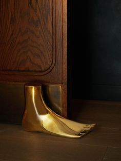 a close up of a gold object on the ground near a cabinet with its door open