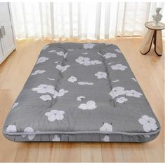 a grey and white flower print mattress on the floor