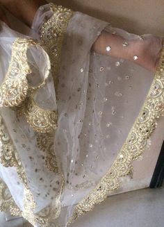 More dupatta here in our collection https://www.etsy.com/shop/neelcreations/?section_id=15880219White with embroidery Indian dupatta.It has beautiful golden border. Scallop border with dull gold color.★ The mirror is not real.★ It can be made in other colors and longer in length also.We can also change the border if you want.Approximate length 88-90 inches. We can increase length so please contact us if you want longer dupatta.These designer dupattas are very much in trend. Pair them with plain White Bridal Dupatta, Gold Organza Choli With Sheer Dupatta, Gold Choli With Sheer Dupatta In Organza, Organza Dupatta With Dabka Work For Wedding, Wedding Chanderi Dupatta With Dabka Work, Wedding Organza Dupatta With Dabka Work, Lace Salwar Kameez With Dupatta For Wedding, Gold Embroidered Fabric With Dabka Work For Party, Wedding Dupatta With Dabka Work In Dola Silk