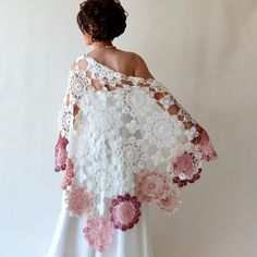 a woman in a white dress is wearing a shawl with pink flowers on it