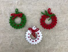 three crocheted christmas wreaths with bows on them