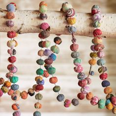 colorful beads hang from a tree branch