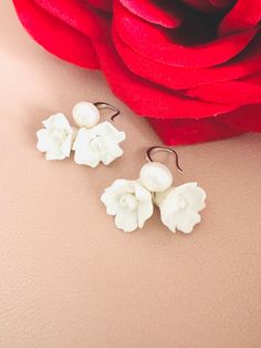 Skillfully crafted by hand, each earring showcases two delicate white clay flowers adorned with freshwater pearls. These exquisitely made flower bridal earrings are a perfect choice for your special day. 🖤 M A T E R I A L S  *  A N D  *  S I Z E  🖤 ❇️ MATERIAL & METAL: Brass- Clay Flower/Freshwater Pearl/Cubic Zirconia ❇️ METAL PLATING: Silver/Gold/Rose Gold ❇️ ESTIMATED SIZE: 3cm Length (Included Finish Post) ❇️ ESTIMATED WEIGHT: 8gram ❇️ QUANTITY: 1pair ❇️ LEAD-FREE & NICKEL FREE 🖤 A V A I L A B L E  *  F I N I S H 🖤 ❇️#1-CZ HOOP ❇️#2-CRYSTAL POST ❇️#3-PLAIN FISH HOOK ❇️#4-TEXTURE FISH HOOK ❇️#5-CLIP ON ❇️#6-PLAIN HOOP ❇️#7-CZ FISH HOOK ❇️#8-CZ FISH HOOK 🖤 C U S T O M I Z I N G  *  A N  *  E X I S T I N G  *  P I E C E 🖤 If you love this piece but feel you would like to make a few Clay Flower Jewelry, Clay Flower, Clay Flowers, Flower Jewelry, White Clay, Jewelry Wedding, Boho Floral, Flower Jewellery, Fish Hook