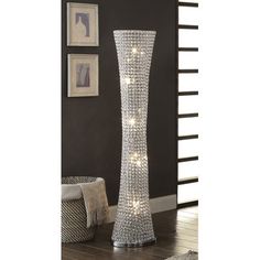 a tall crystal vase sitting on top of a wooden floor next to a rug and pictures