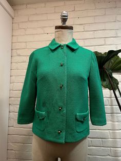 This 1960s jacket, crafted from vibrant Kelly green wool, captures the era's bold flair. Its tailoring, rich texture, and cute gold buttons offers a striking standout piece that embodies the lively spirit of the '60s. (Good Vintage Condition, has a few little tears but still great blazer)  Bust- 34" Waist- 34" Shoulders- 14" Sleeve- 16.5" Length- 20" Size: Extra small- small Retro Green Formal Outerwear, Classic Green Blazer With Button Cuffs, Retro Green Blazer For Workwear, Retro Green Blazer For Work, Vintage Green Outerwear For Formal Occasions, Vintage Green Formal Outerwear, Vintage Green Winter Blazer, Vintage Green Single Breasted Blazer, Vintage Green Single-breasted Blazer