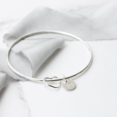 This sterling silver bangle is made using 2mm wide sterling silver wire and looks lovely on its own or part of a stack. The 1cm rounded disc charm can be personalised with letters/numbers or symbols (heart, angel, paw print) with upto 6 characters across - please state what you would like in the personalisation box at checkout or drop me a message if you have any queries at all.  This bangle comes in a variety of widths and sizes, please choose at checkout. If you would like a different width to Personalized Silver Heart Bangle Bracelet, Personalized Sterling Silver Bracelet For Anniversary, Personalized Sterling Silver Round Bracelet For Anniversary, Silver Heart Charm Bracelet For Birthday, Personalized Silver Sterling Bangle, Sterling Silver Name Bracelet With Heart Charm For Anniversary, Personalized Sterling Silver Bangle, Anniversary Sterling Silver Name Bracelet With Heart Charm, Silver Hand Stamped Charm Bracelet For Anniversary