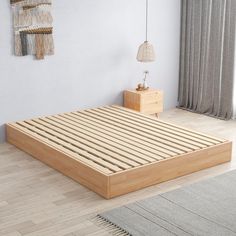 a bed with wooden slats in a white room next to a rug and window