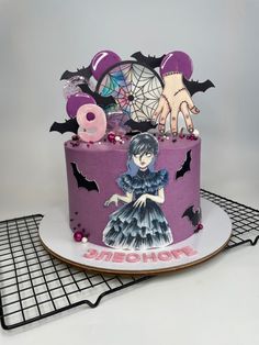 a purple cake decorated with an image of a woman and bats