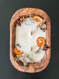 an orange slice is cut in half on a wooden platter with herbs and spices