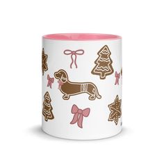 a pink and white coffee mug with brown dachshund christmas cookies on it