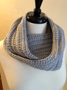 a gray and white crochet cowl on a mannequin headdress