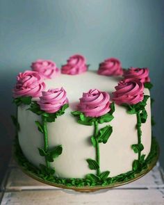 a white cake with pink frosting roses on it