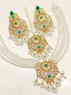 Add a touch of elegance and glamour to your attire with this stunning Shibra Mini Mala Zircon Necklace Set from My Jewel Box. The exquisite set includes a beautiful necklace, matching earrings and a Tikka that boast natural, multiple gemstones set in gold-coloured alloy. The jewellery set is perfect for special occasions like engagements, weddings, anniversaries, birthdays and Valentine's Day. The set's intricate design and excellent cut grade make it a must-have piece of Indian/Pakistani Bridal Elegant Stone Work Jewelry Sets For Party, Elegant Kundan Sets With Meenakari Detailing, Elegant Sets With Intricate Design For Reception, Elegant Kundan Formal Sets, Elegant Kundan Sets For Formal Occasions, Elegant Kundan Sets For Festivals, Elegant Cutdana Jewelry Sets For Festive Occasions, Elegant Gold Sets With Stone Work, Elegant Meenakari Bridal Sets For Eid