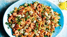 pasta with shrimp, fettuccine and parsley on a blue platter