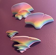 three scallop shells on a purple surface