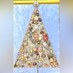 a christmas tree made out of buttons on a blue background with gold trimmings