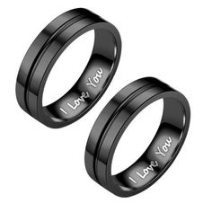 two black wedding rings with i love you written on the inside of each ring, one is