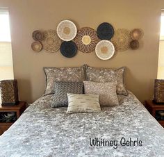 a bed with pillows and decorative wall hangings above it