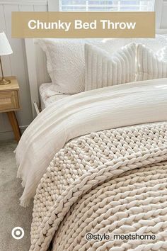 a bed with white blankets and pillows on top of it